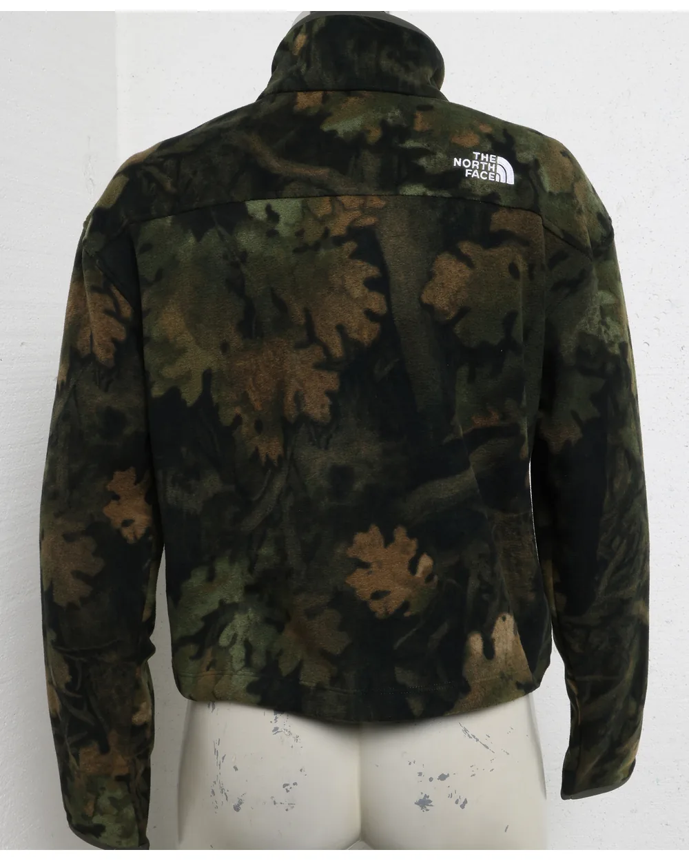 Camouflage fleece as shot on a studio mannequin against a marked wall