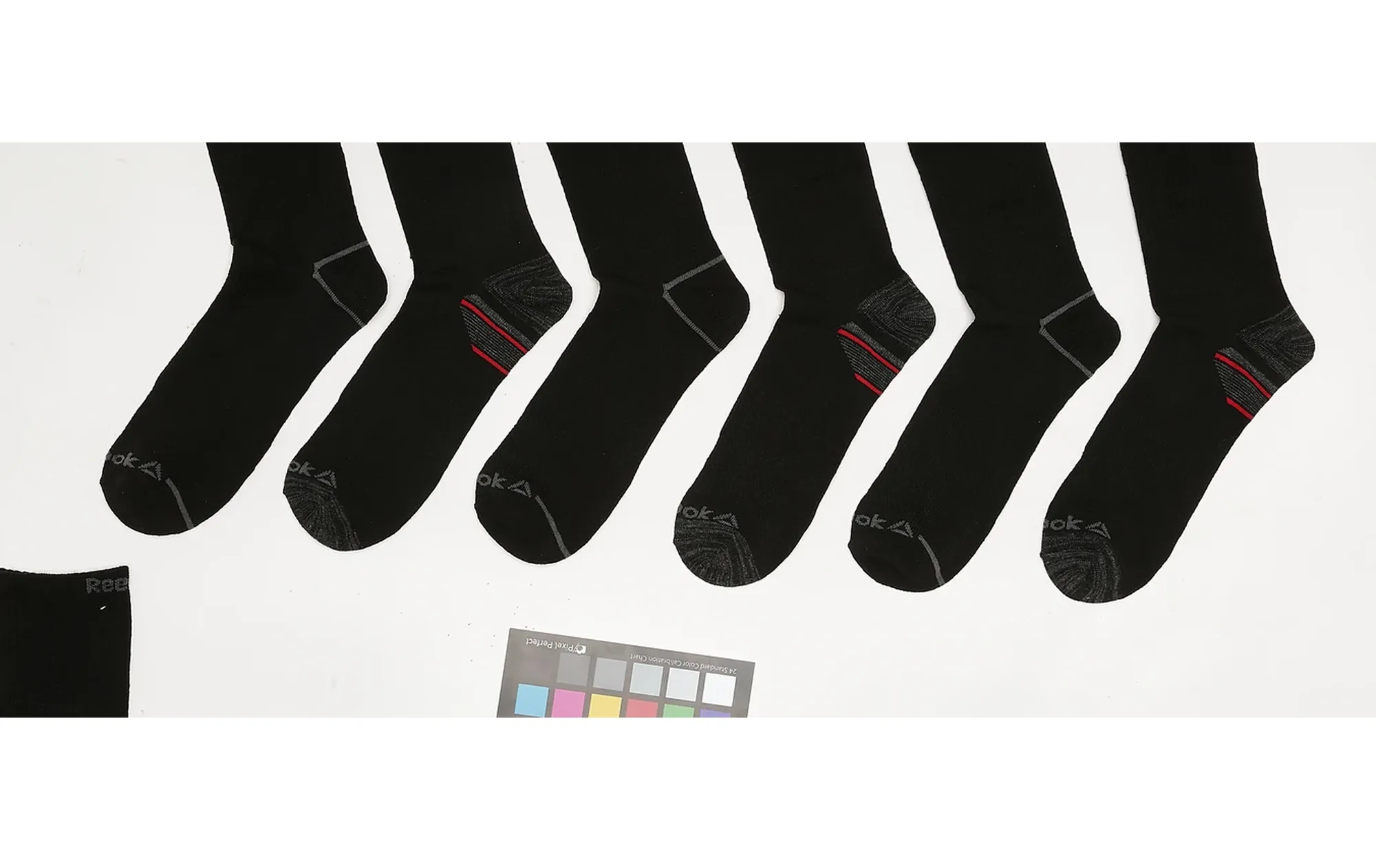 Sock range as shot, scattered on a studio table with a colour checker