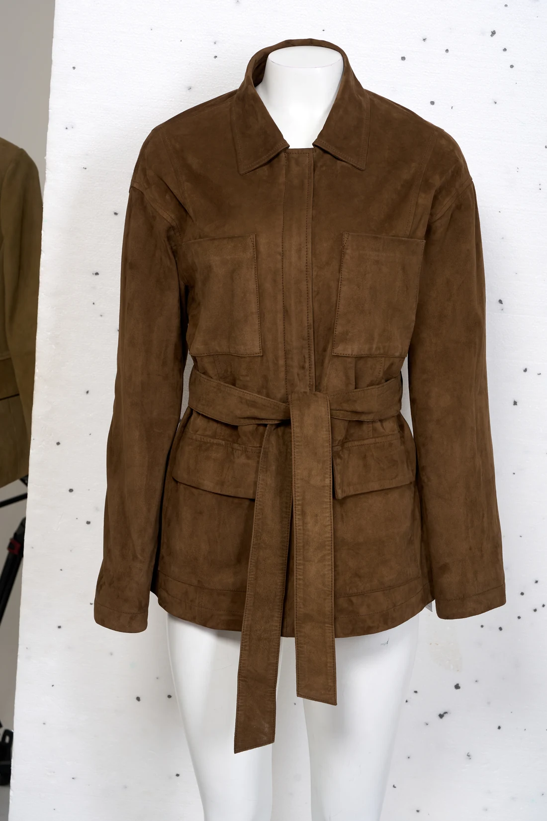 Suede jacket as shot on a mannequin against a marked studio backdrop